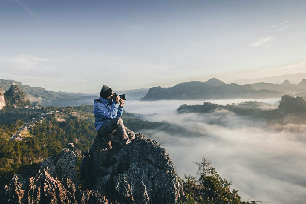 Photographer working with used camera gear and editing software, showing how to make money with photography using budget-friendly tools.