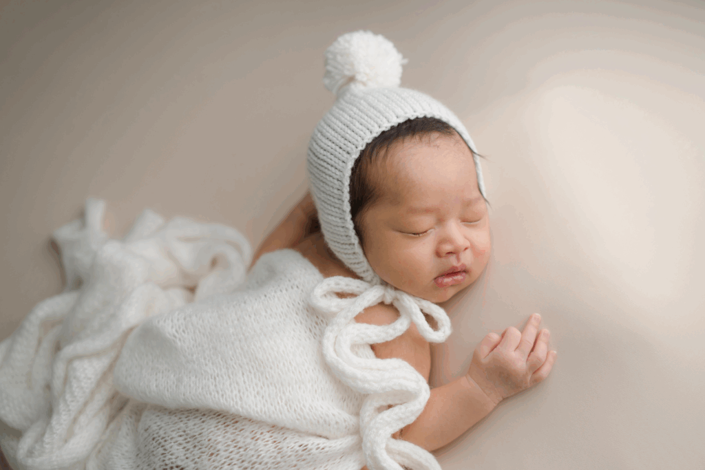 A newborn peacefully lying on a soft blanket with natural window light, showing safe and simple posing for beginners.