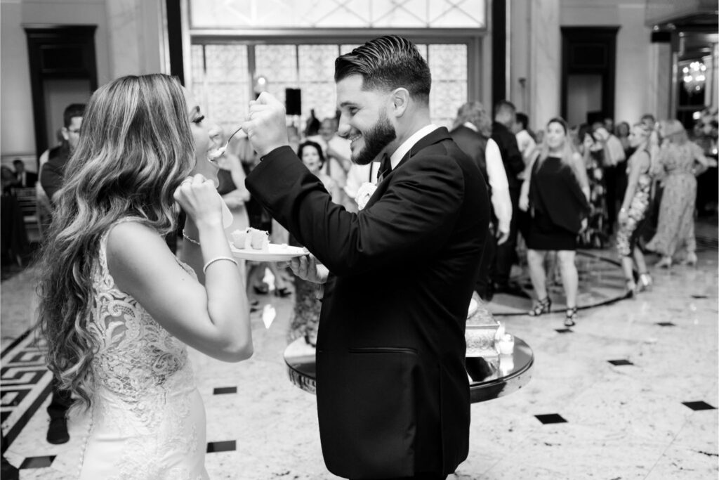 Groom feeding the bride a spoonful of cake, captured to highlight the fun and candid moments preserved through same-day edits.