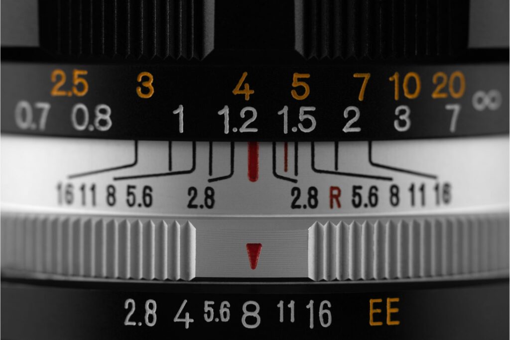 Close-up of a camera lens showing aperture and depth of field markings — the controls the exposure triangle wrong framework treats as interchangeable
