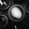 several black camera zoom lenses arranged closely together viewed from above