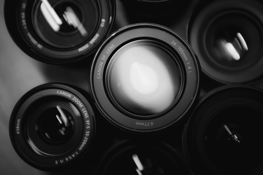 several black camera zoom lenses arranged closely together viewed from above