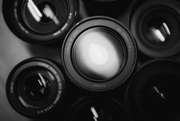 several black camera zoom lenses arranged closely together viewed from above