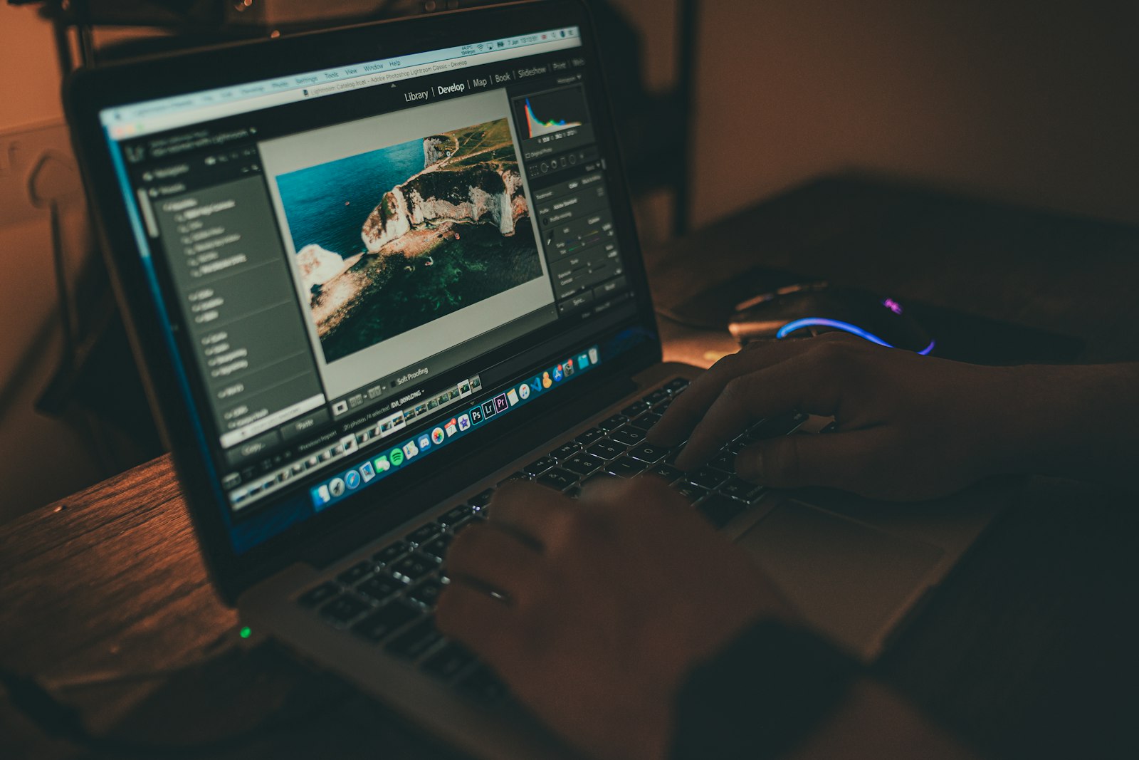 person editing an image on a laptop in a dark room