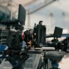 cinema cameras with external monitors mounted on rigs at an outdoor location