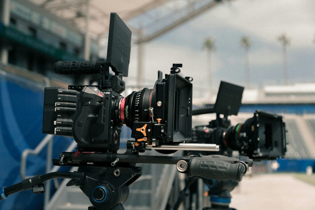 cinema cameras with external monitors mounted on rigs at an outdoor location
