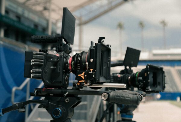 cinema cameras with external monitors mounted on rigs at an outdoor location