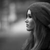 black and white profile portrait of a woman wearing a knit beanie with a softly blurred background
