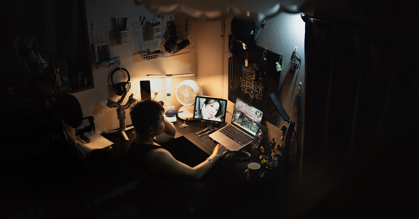 person working on a laptop displaying a photo in a dimly lit room at night