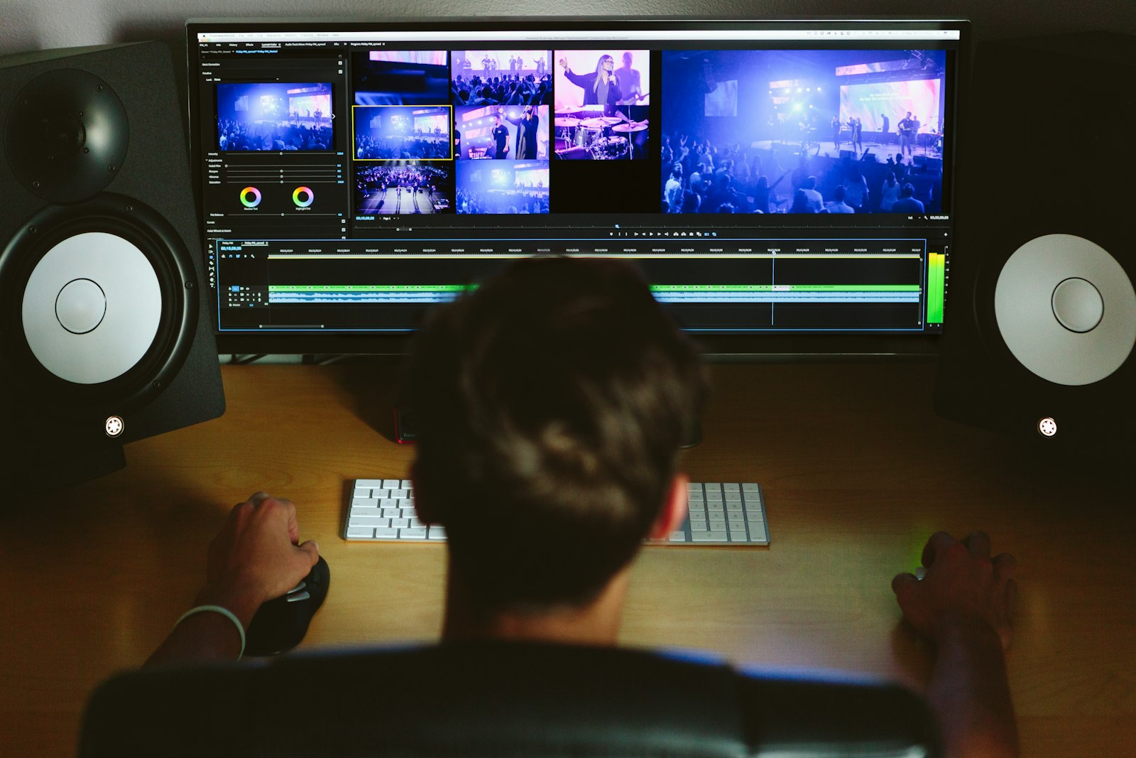 person reviewing video footage on a computer editing timeline with studio monitors