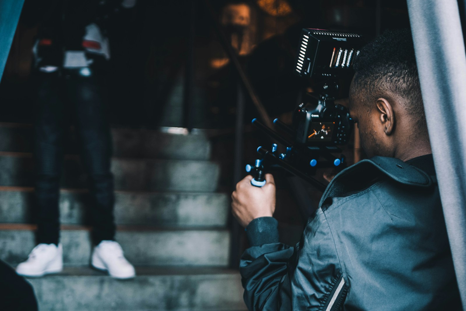 camera operator filming a subject on outdoor steps with a professional cinema camera