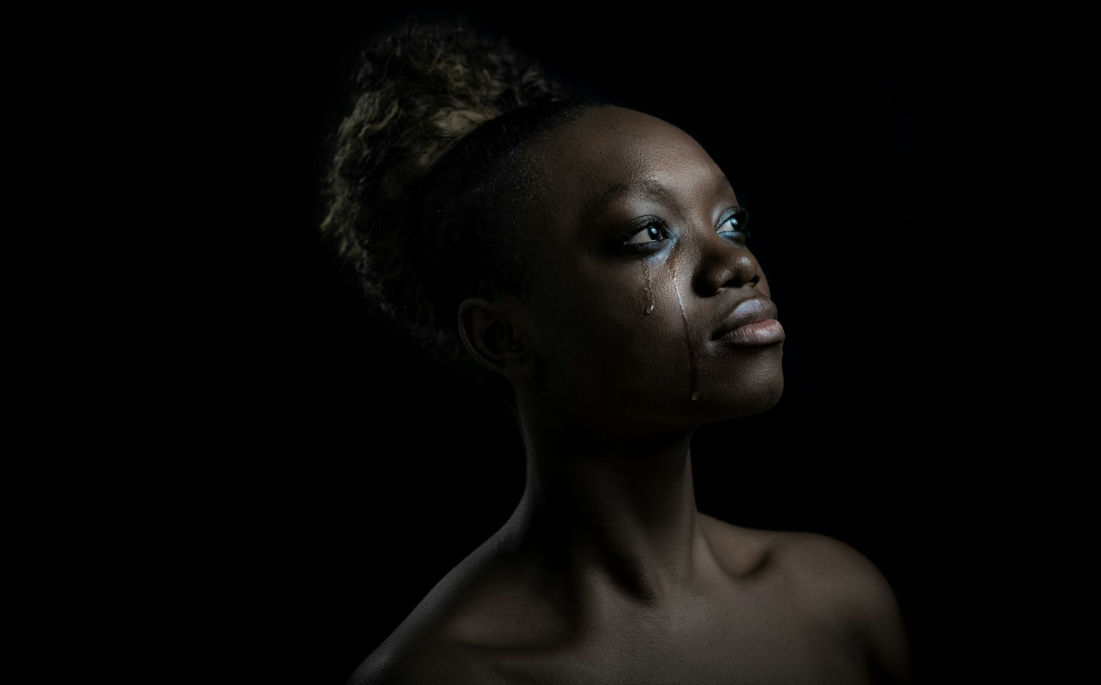 portrait of a person against a black background with rim light on the shoulders and face