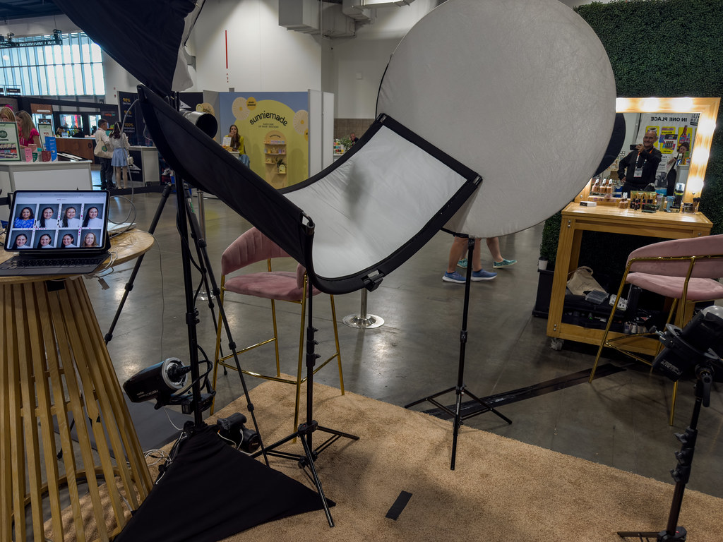 studio portrait lighting setup with softbox, reflector, and light stands at an indoor expo