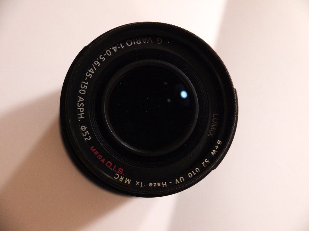 Panasonic Lumix G Vario zoom lens viewed from the front on a white surface